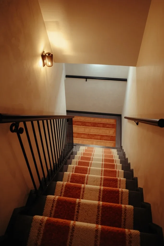 24 Basement Ideas That Transform the Most Overlooked Space Into Your Favorite Room 24 basement staircase, featuring a striped wool stair runner in cream